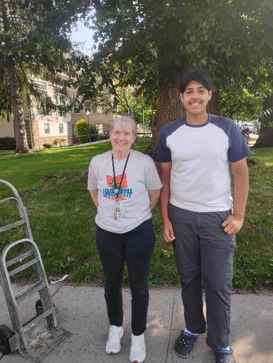 A Pages for Change volunteer and a librarian standing outside the library